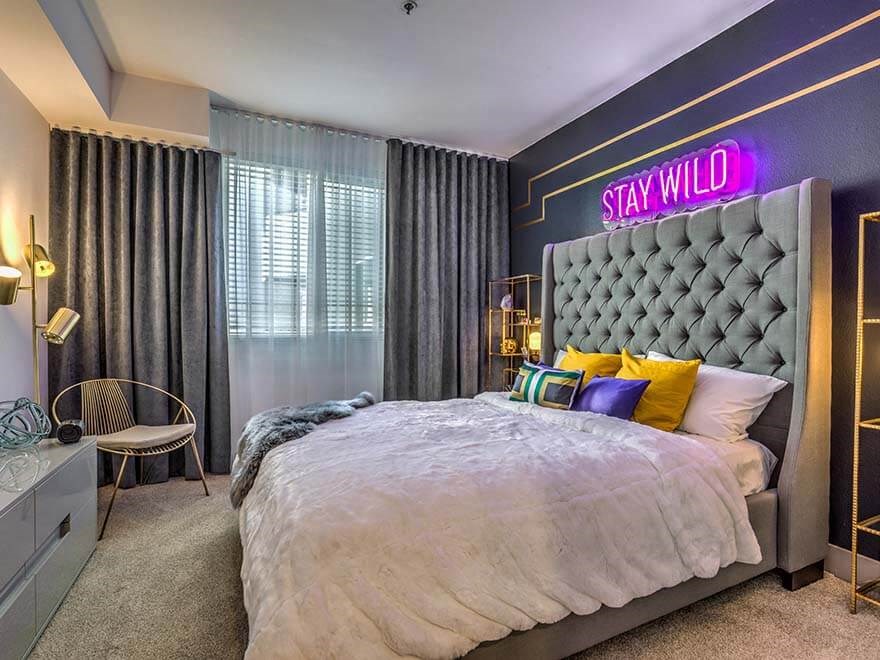 a bedroom with a large bed and a purple wall