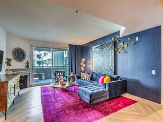 a living room with blue walls and a purple rug