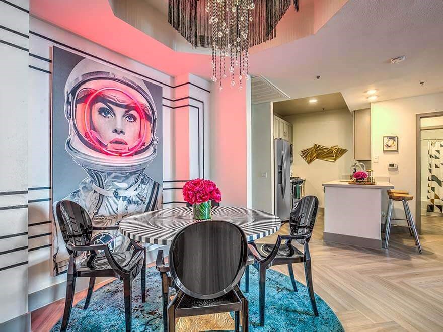 a dining room with a table and chairs and a painting on the wall