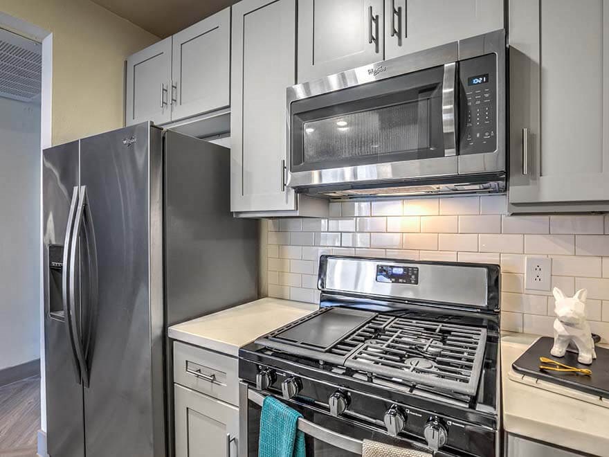 a kitchen with stainless steel appliances and white cabinets