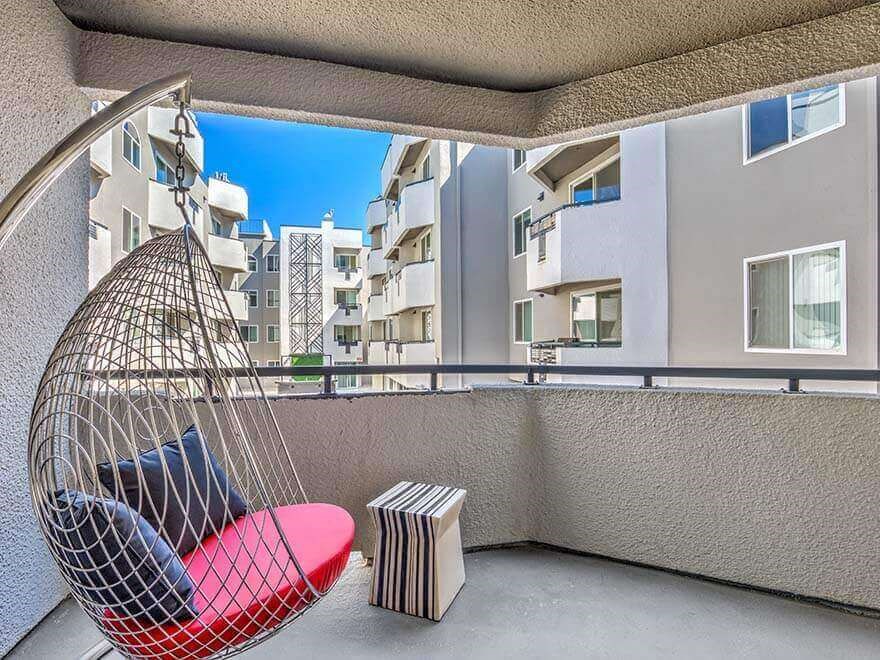 a hammock on a balcony with a view of the city