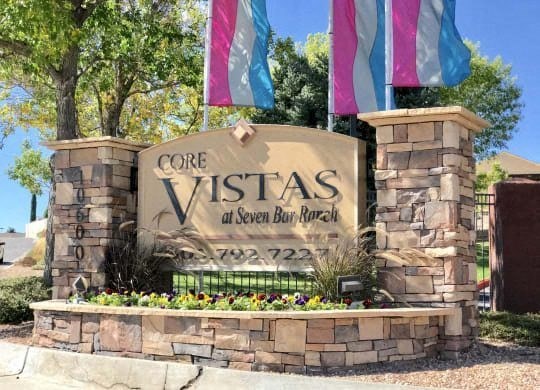 a sign for the vistas at seven bear resort in front of flags