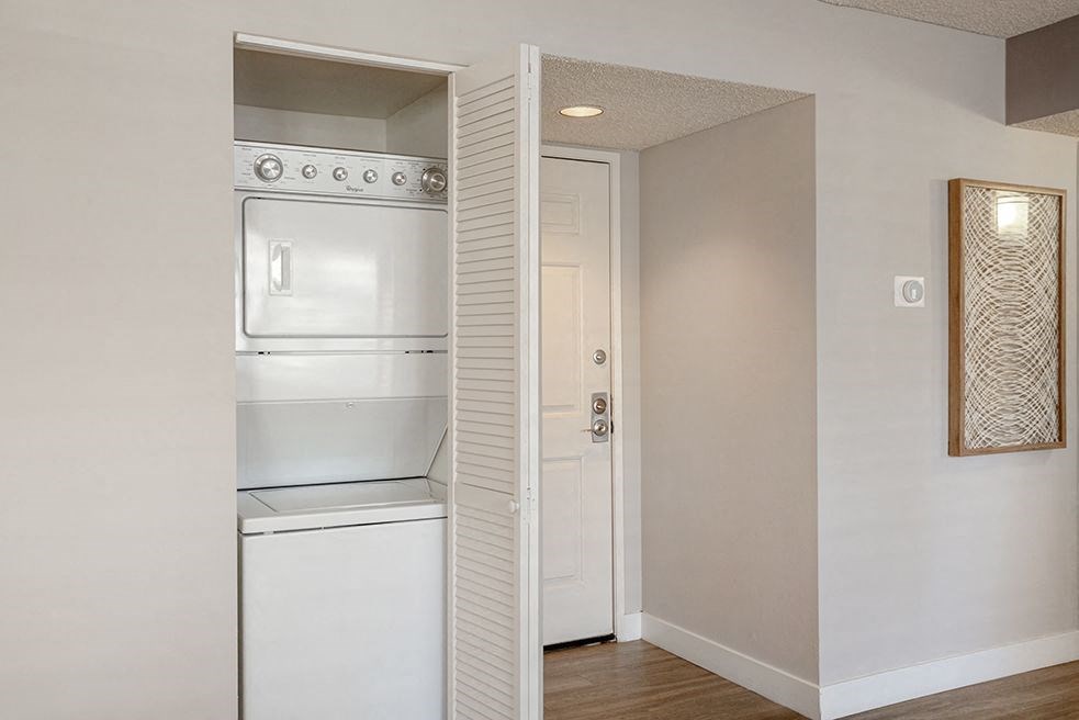 an empty kitchen with a white stove and refrigerator