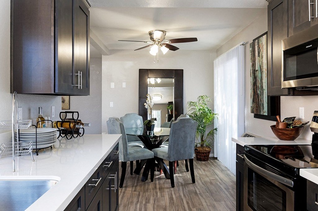 A kitchen with a dining table and chairs. A kitchen with a dining table and chairs at The Casas Apartments, San Diego, CA