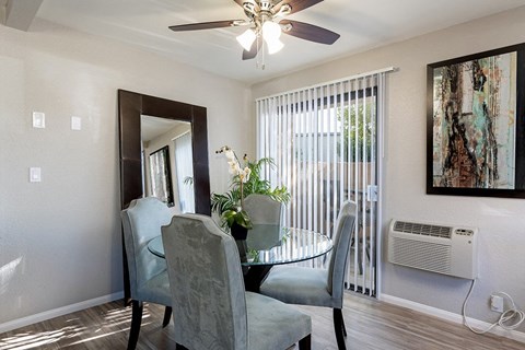 A dining room with a glass table and chairs at The Casas Apartments, San Diego