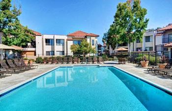 A swimming pool in front of apartment buildings at The Casas Apartments, San Diego