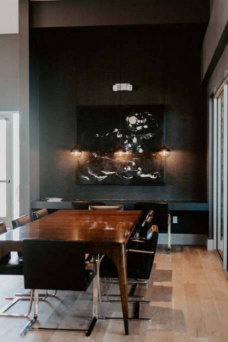 a dining room with a wooden table and black walls