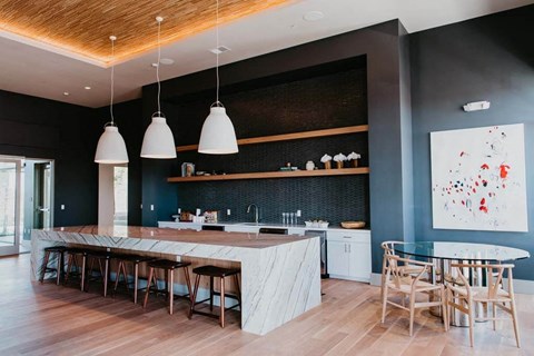a large kitchen with a long island with a marble countertop