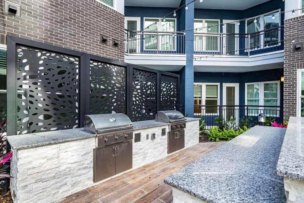 an outdoor kitchen with two bbq grills