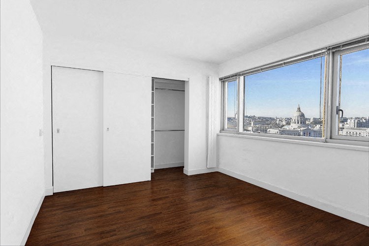 Studio Apartments in San Francisco, CA - Trinity Place at 1190 - Bedroom with a Large Window, White Walls, Wood-Style Flooring, & a Spacious Closet