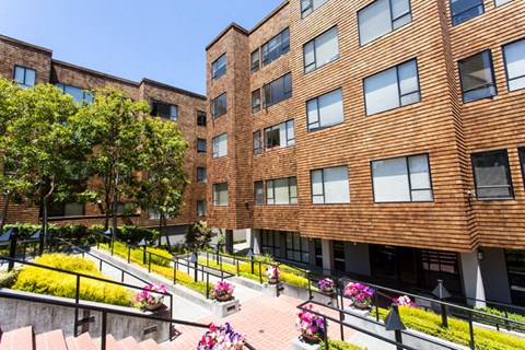 a large brick building with trees in the background