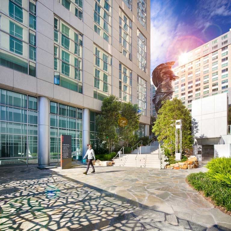 a person walking in front of a large building