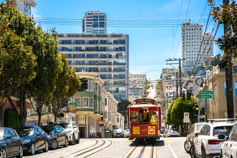 a red streetcar travels down a street in san francisco