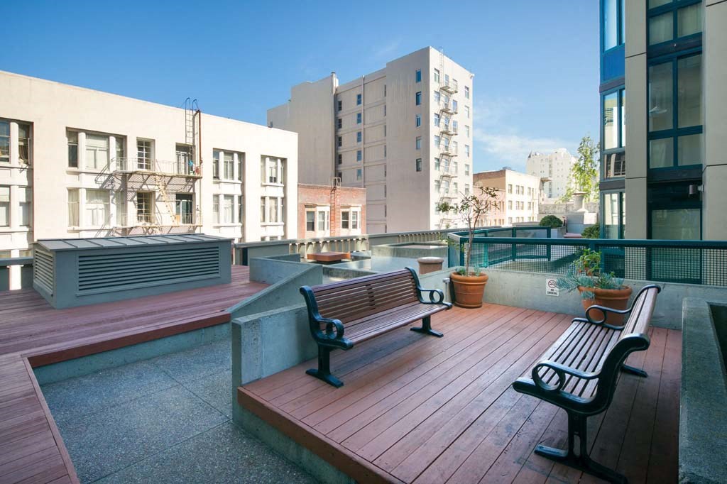 a bench on a balcony with a city in the background