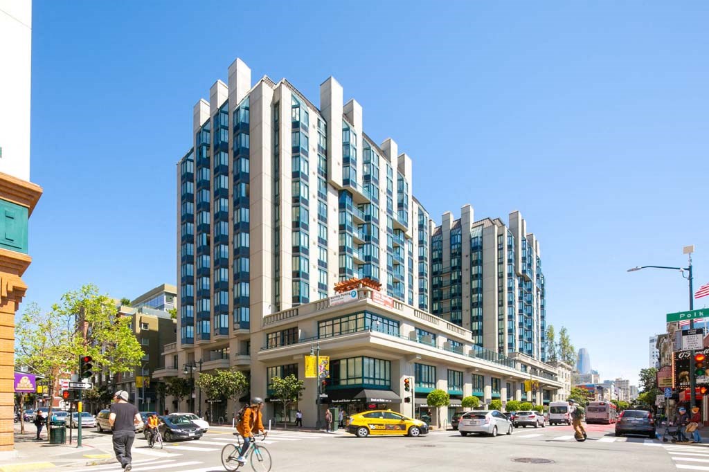 a man riding a bike down a street next to a tall building