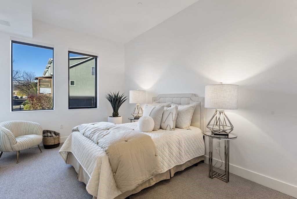 a bedroom with a bed and two windows