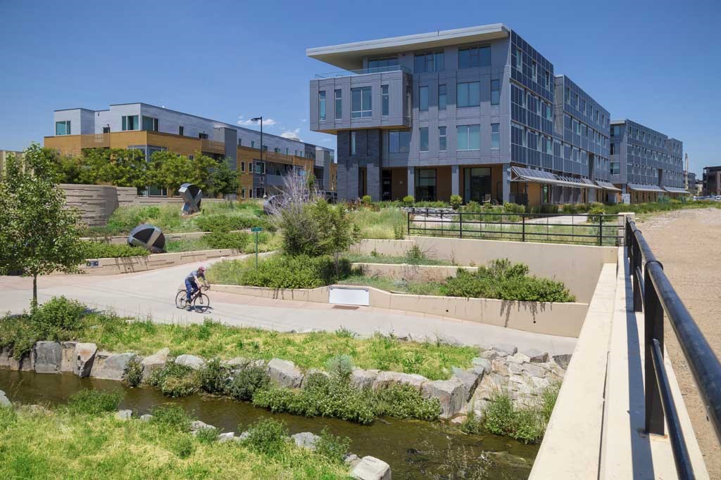a person riding a bike on a sidewalk in front of a building