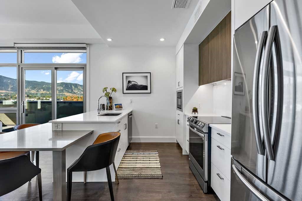 a kitchen with a refrigerator freezer next to a stove top oven