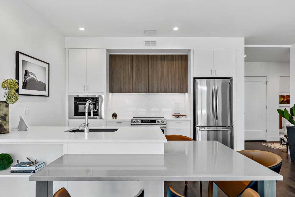 a kitchen with a refrigerator freezer next to a stove top oven