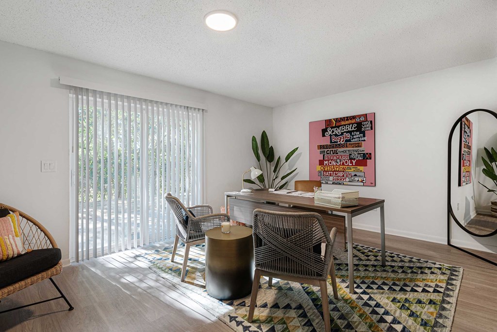 a desk with a chair and a table in a room with a sliding glass door