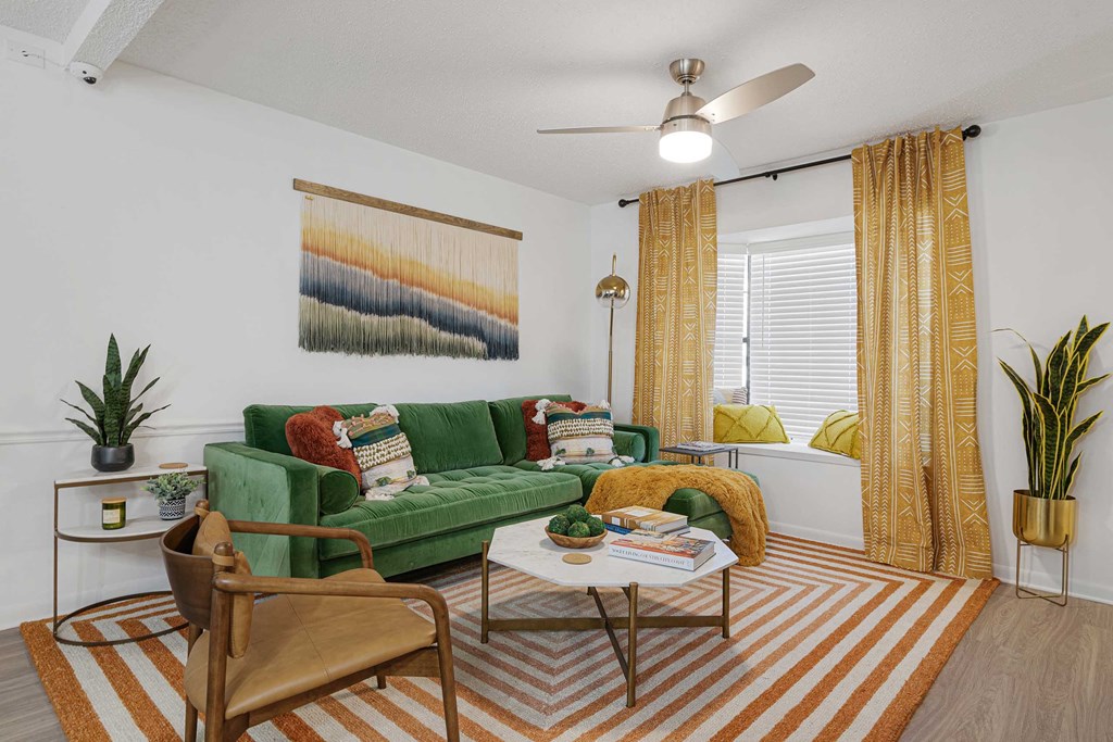a living room with a green couch and yellow curtains