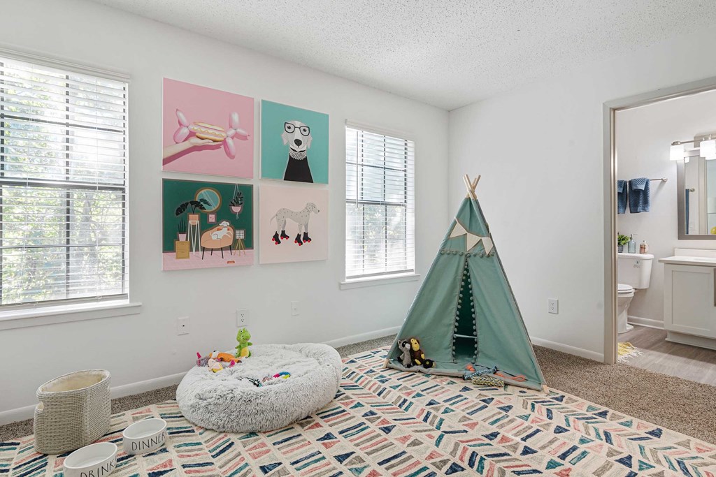 a bedroom with a teepee and pictures on the wall