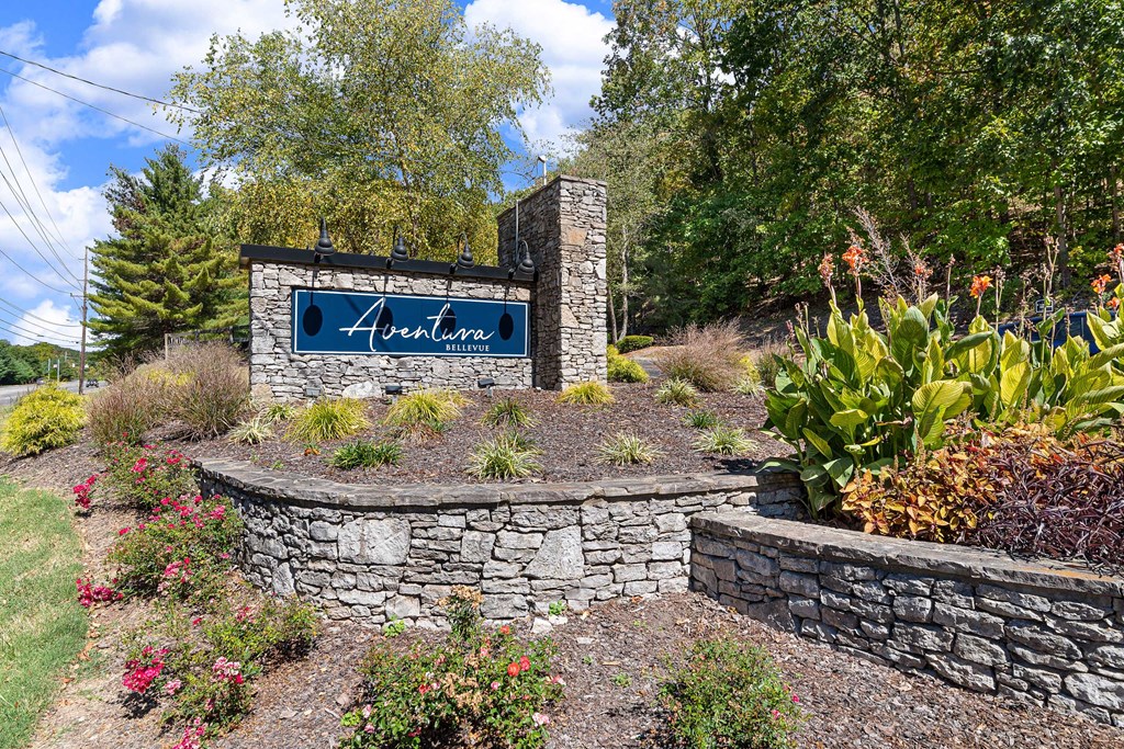 a stone retaining wall with a sign in front of it