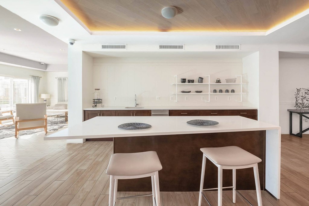 a kitchen with a large island with two stools in front of it