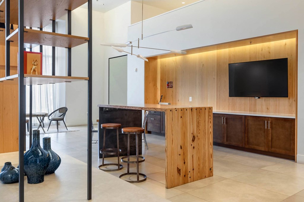a kitchen island with stools in front of it and a tv on the wall
