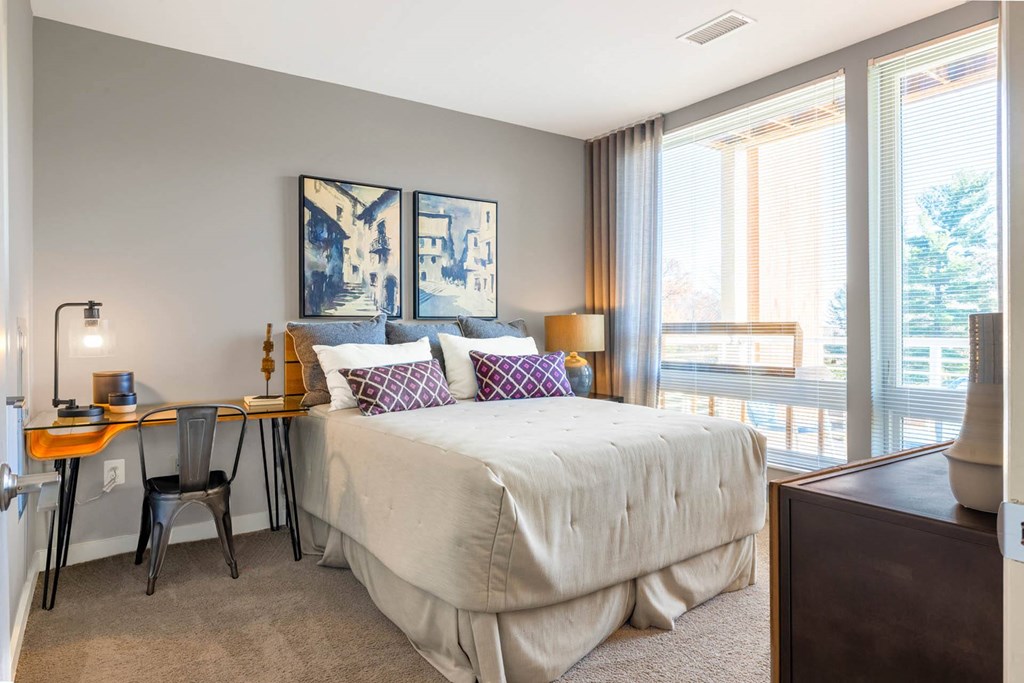 a bedroom with a bed and a desk with a chair