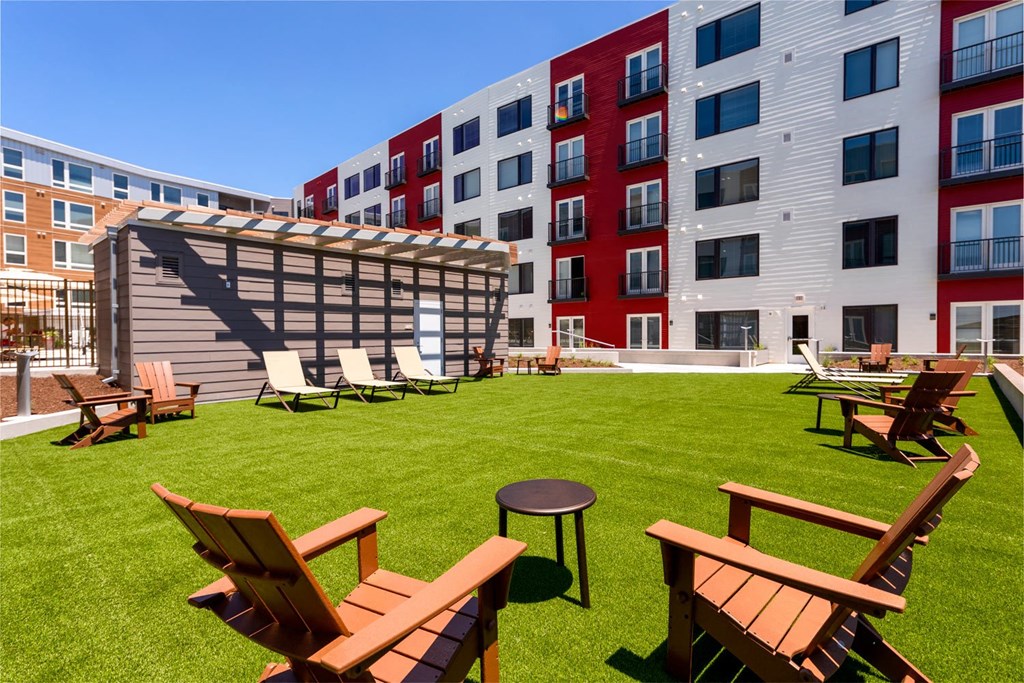 a grassy area with chairs and tables on a sunny day