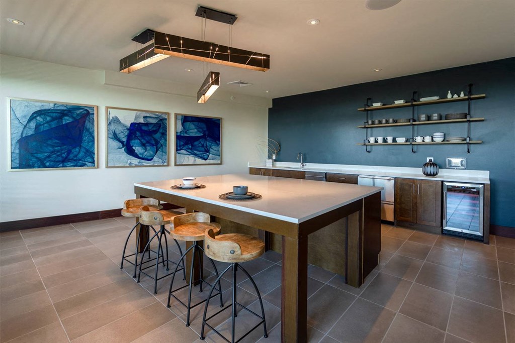a kitchen with a long counter and stools in front of it
