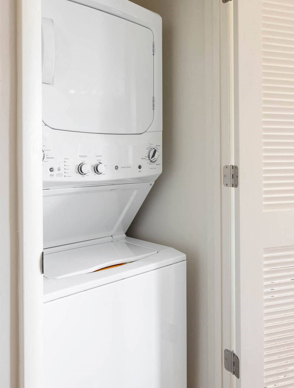 a white washer and dryer in a small laundry room