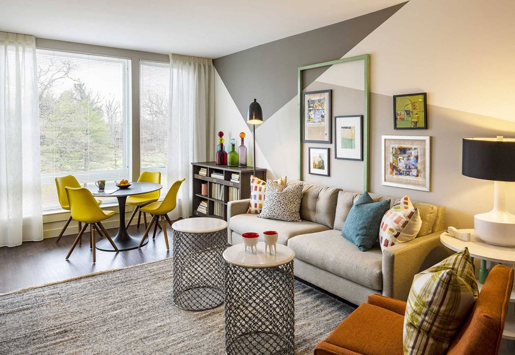 a living room with a couch table and chairs and a large window