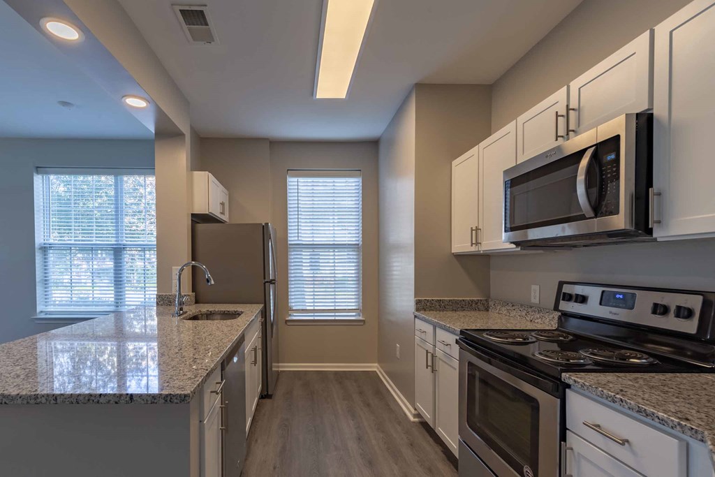 a kitchen with white cabinets and gray countertops