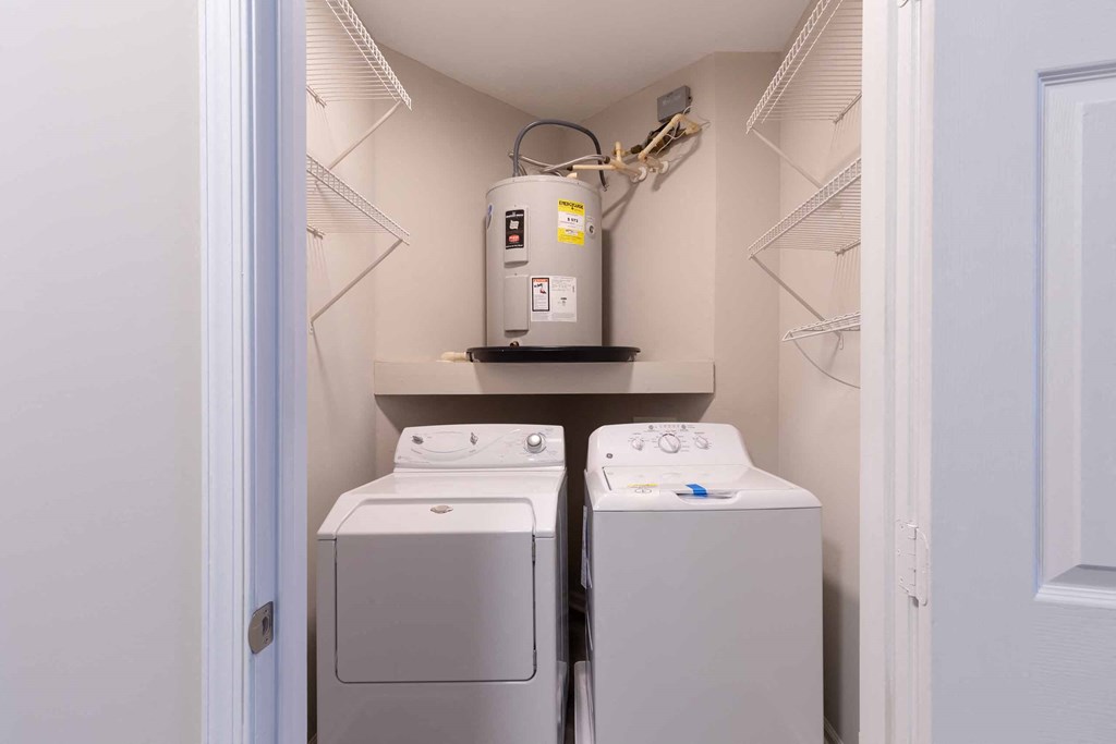 a small laundry room with two washers and a dryer