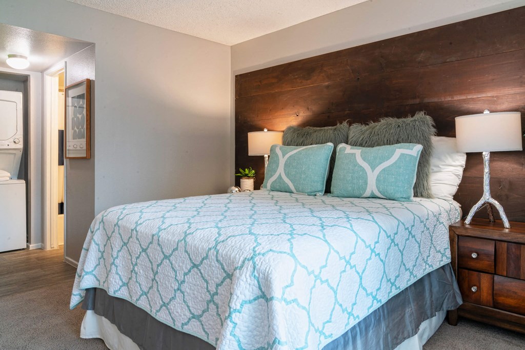 A bedroom with a bed and a wooden accent wall at Westmount at Urban Trails, Mesa