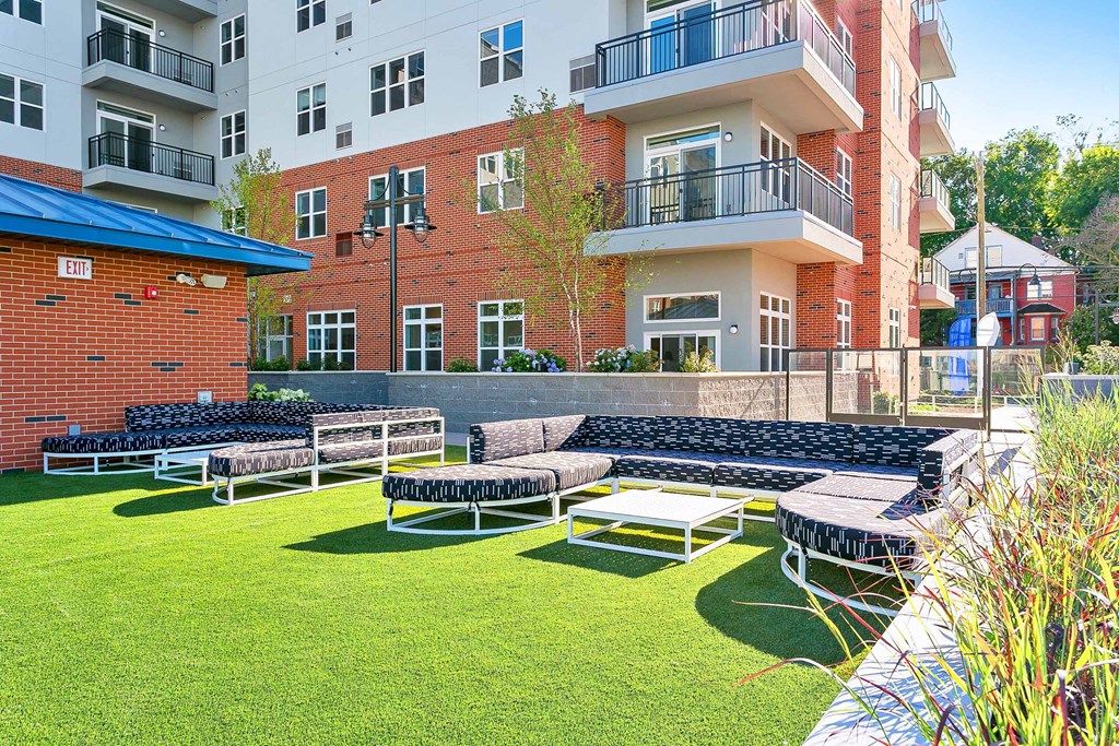 a group of lounge chairs sitting on top of a lush green field