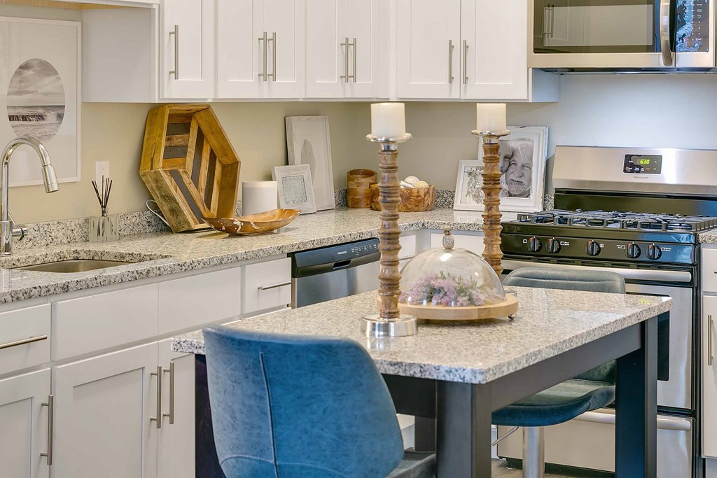 a kitchen with white cabinets and blue chairs