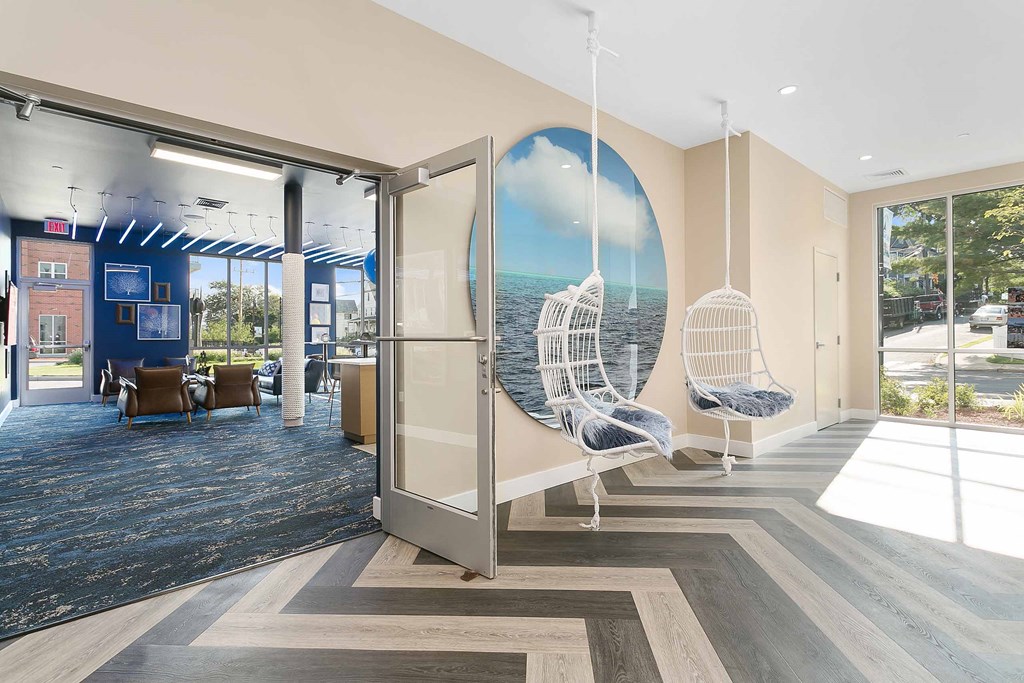 a view of the lobby with two hanging chairs and a large mural on the wall