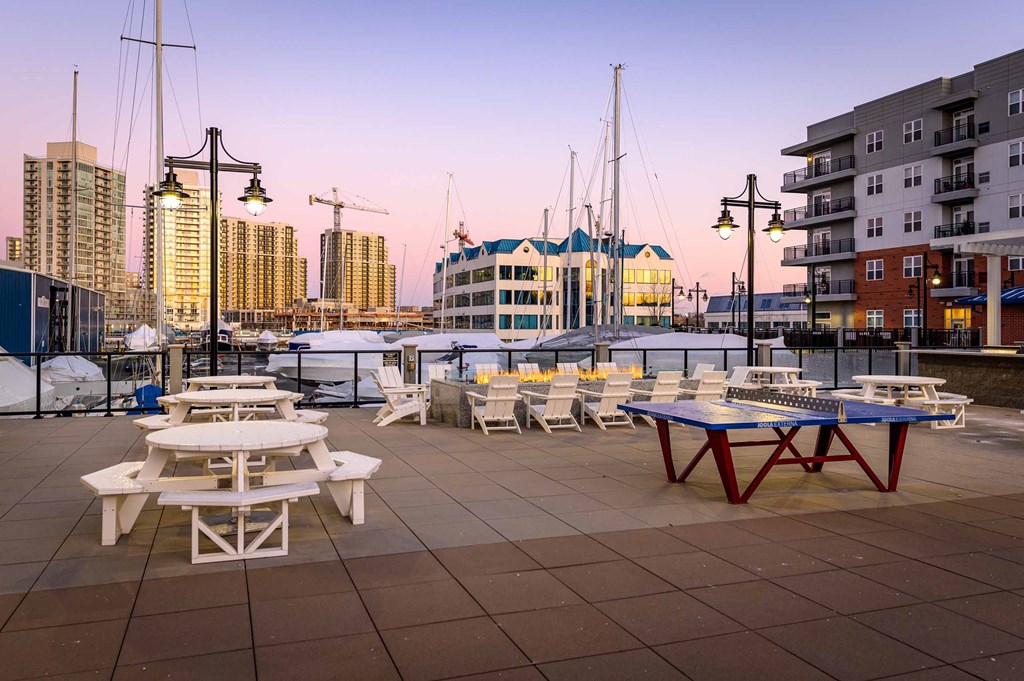 a terrace with tables and chairs overlooking a marina