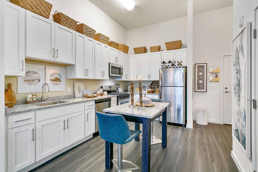 a kitchen with white cabinets and a blue table