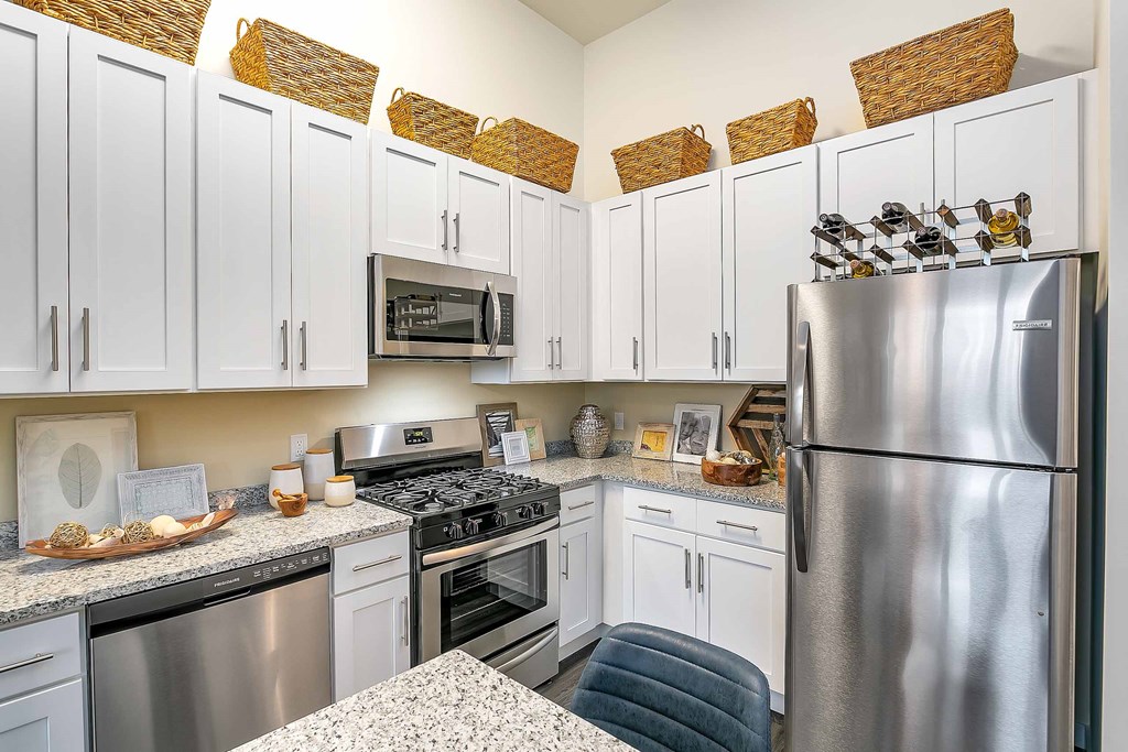 a kitchen with white cabinets and stainless steel appliances