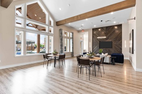 the gathering place at gardner village resident lounge with tables and chairs and large windows