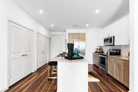a kitchen with white cabinets and a marble counter top