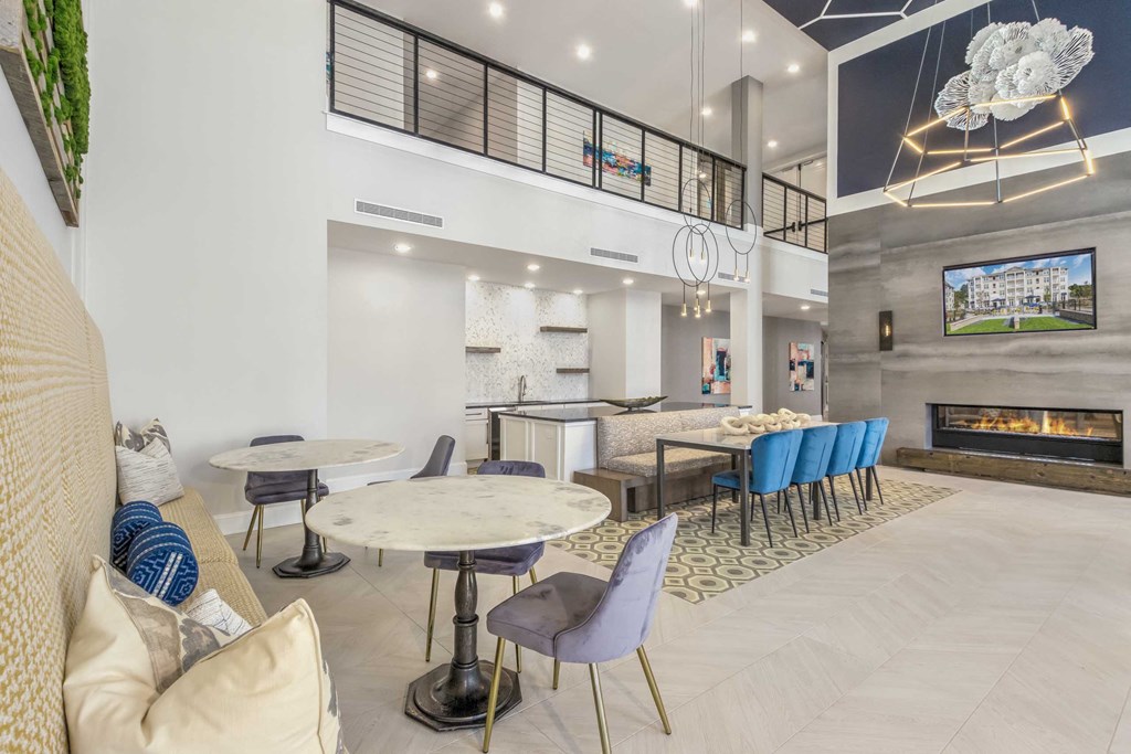 a lobby with tables and chairs and a fireplace