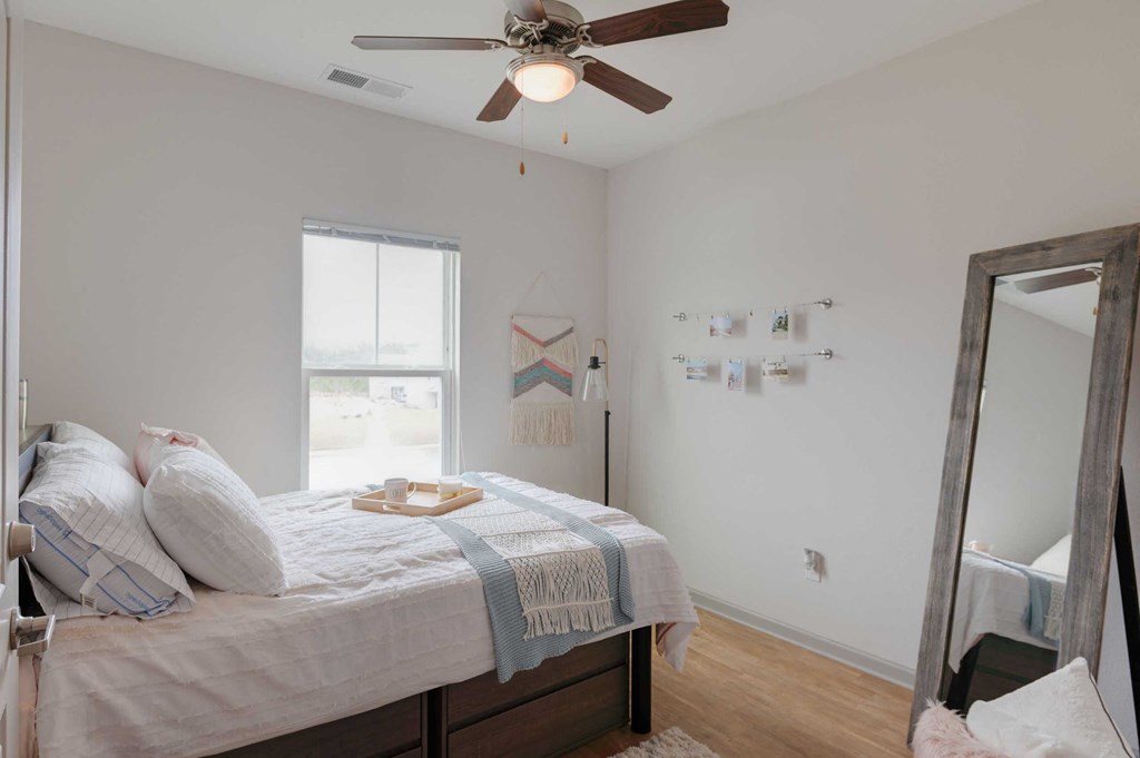 a bedroom with a bed and a ceiling fan