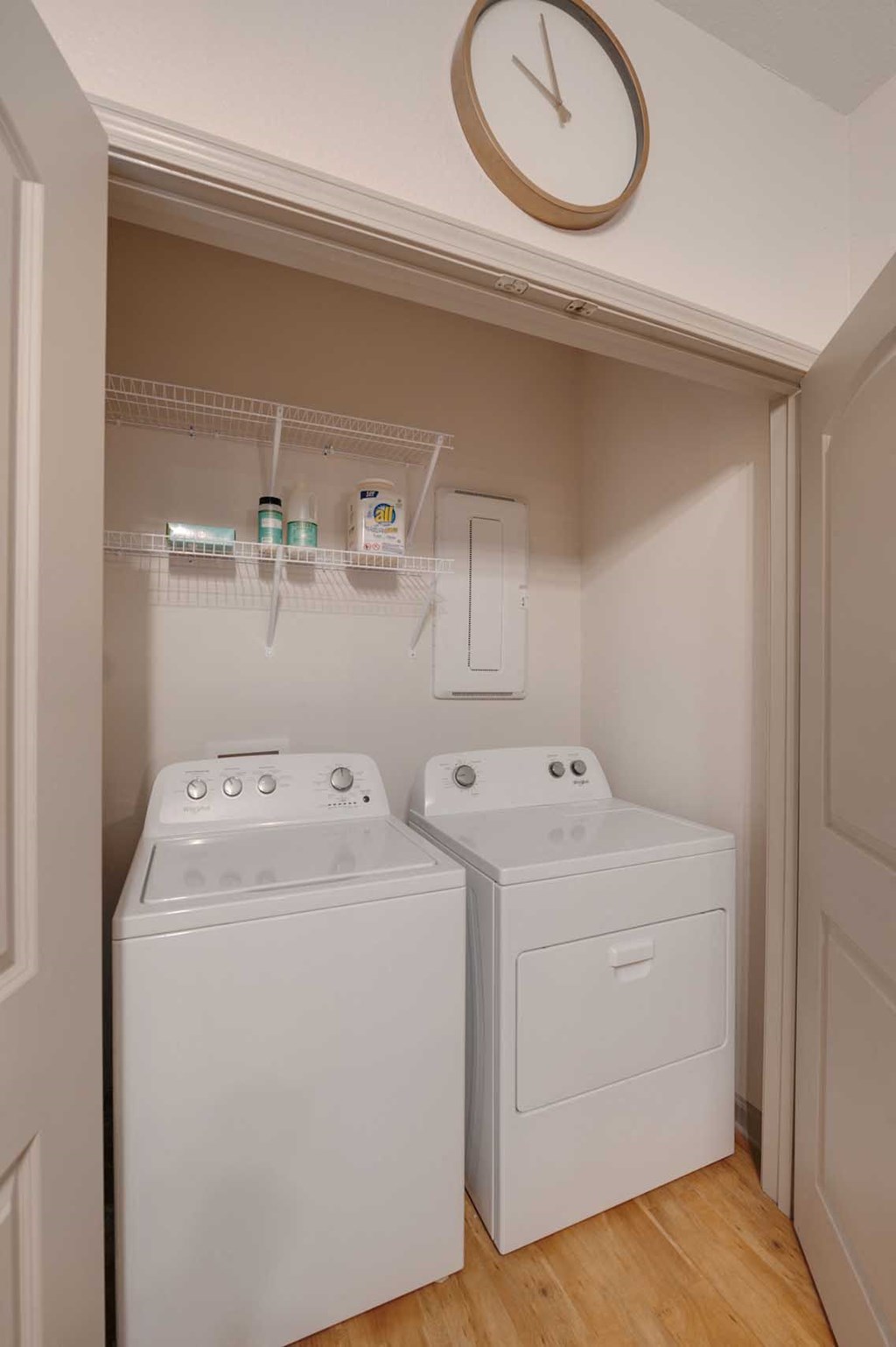 a washer and dryer in a room with a clock on the wall