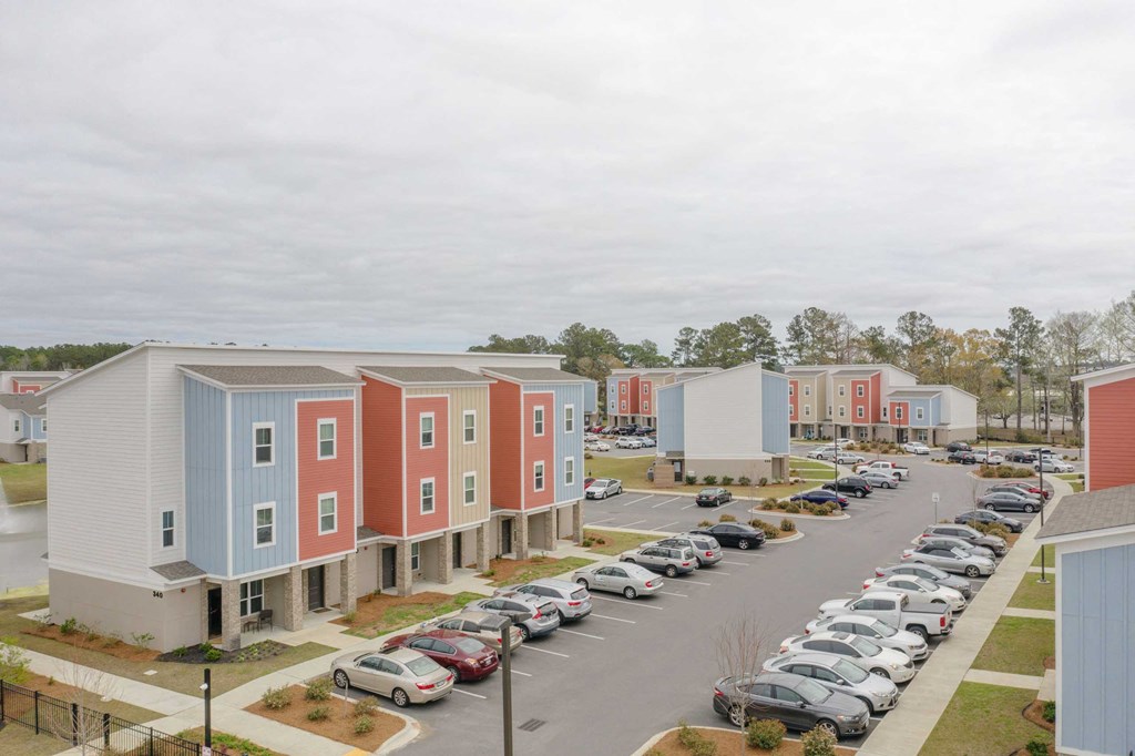 a row of colorful houses next to a parking lot