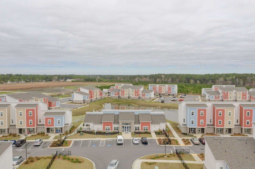 an aerial view of an apartment complex with a parking lot